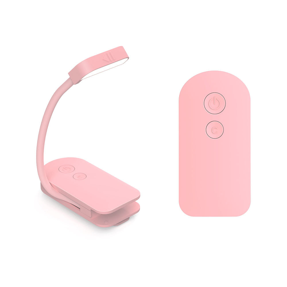 A pink clip-on reading light shown next to its matching remote control on a clean white background.
